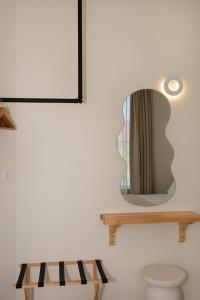 a mirror on a wall next to a bench at Ellinas Hotel in Chrysi Ammoudia +87 photos