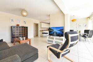 a living room with a couch and a tv at Puerto Marina 10 - Pasito Blanco in San Bartolomé de Tirajana
