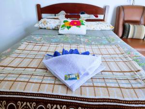 a bed with two towels on top of it at Minha casa pousada in Botucatu