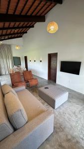 a living room with couches and a flat screen tv at Casa de Campo Morada Nova in Areia