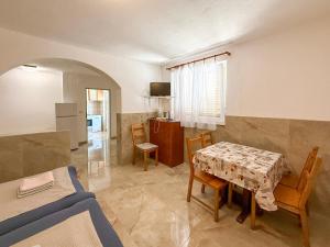 a kitchen and dining room with a table and chairs at Lantana ex Villa Americana in Karlobag