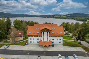 an aerial view of a building with a lake in the background at Jen tak Lipno in Lipno nad Vltavou