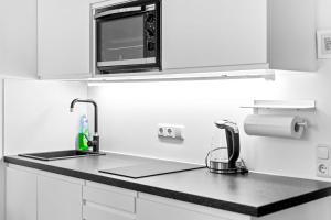 a kitchen with a sink and a microwave at Ferienwohnung Harmonie mit Pool in Sankt Englmar