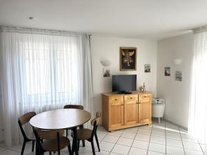 a living room with a dining room table and a television at Ferienwohnung Möwe mit Balkon und einem Strandkorb im Sommer in Zempin