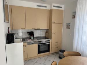 a kitchen with wooden cabinets and a stove top oven at Ferienwohnung Möwe mit Balkon und einem Strandkorb im Sommer in Zempin +32 photos