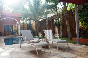two chairs and an umbrella next to a pool at VILLA UNAHANA in Valladolid