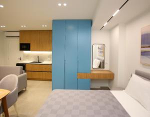 a bedroom with a blue wall and a kitchen at Gledors Luxury Apartments in Vlorë