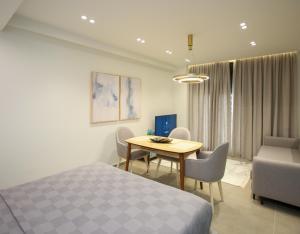 a bedroom with a bed and a table and chairs at Gledors Luxury Apartments in Vlorë