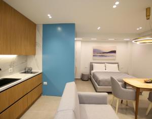 a bedroom with a bed and a kitchen with a table at Gledors Luxury Apartments in Vlorë