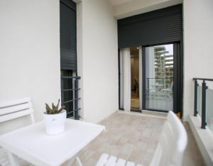 a white dining room with a white table and chairs at Gledors Luxury Apartments in Vlorë +38 photos