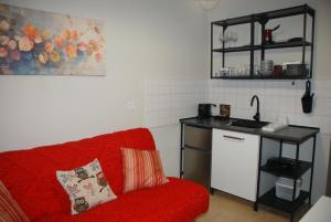 a living room with a red couch and a kitchen at Gallery Rooms Ierissos in Ierissos