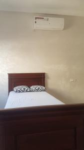 un letto con testiera in legno e presa d'aria di Ajdir a Ajdir