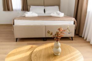 a vase on a table in a room with a bed at Carmen Old Town Apartments in Sarajevo +31 photos