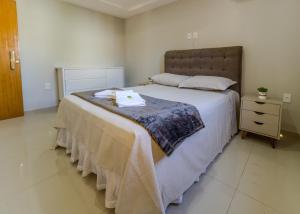 Un dormitorio con una cama grande y una mesita de noche. en Thom's House, en Santa Teresa