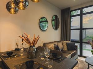 a living room with a table and a couch at Luxurious holiday home nearby the Lower Rhine in Maurik
