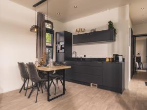 a kitchen with a table and chairs and a sink at Luxurious holiday home nearby the Lower Rhine in Maurik +90 photos