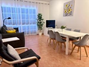 ein Wohnzimmer mit einem weißen Tisch und Stühlen in der Unterkunft Beach Relax Apartment in Porto Santo