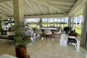 Un comedor con mesa y sillas y plantas. en Golf Villa V, en La Romana 28 fotos más