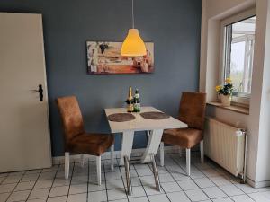 a dining room with a white table and chairs at Fernblick Autal in Scholderup