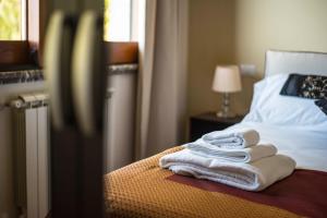 a pile of towels sitting on top of a bed at Villa Sofia in Taormina