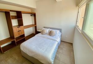 a bedroom with a bed with two pillows and a window at New Sea View with GymGolf Club near Mandinga in Cedro +16 photos
