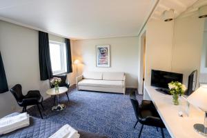 ein Hotelzimmer mit Sofa und Wohnzimmer in der Unterkunft Hotel Norden in Haderslev
