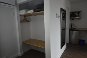 a small room with a bed and a shelf and a microwave at Motel ANF in Drummondville