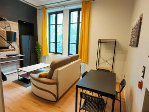 a living room with a couch and a table at Loft moderne dans un palace bourgeois in Aix-les-Bains
