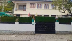 基多Friendly House & Hostel 2的有白色和绿色篱笆的房子