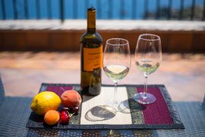 a bottle of wine and two wine glasses on a table at Villa Sofia in Taormina
