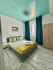a bedroom with a large bed with green curtains at Happy Apartments Mamaia Nord 2 Camere in Mamaia Sat/Năvodari