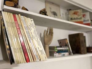 a shelf with a bunch of books on it at Le Grand Gîte in Vaison-la-Romaine