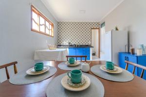 Un comedor con una mesa con cuatro tazas encima. en Thom's House, en Santa Teresa