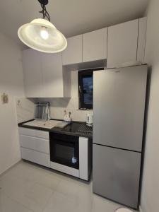 a small kitchen with a refrigerator and a microwave at Šućur holiday home in Preko