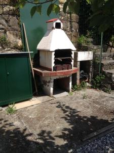 an outdoor brick oven sitting next to a green door at Tramonto sul Mare in Framura +15 photos