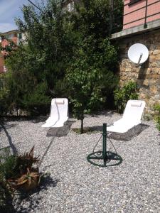 two white chairs and a camera in a garden at Tramonto sul Mare in Framura
