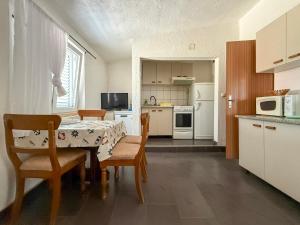 a kitchen with a table and chairs and a kitchen with white appliances at Lantana ex Villa Americana in Karlobag