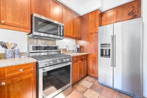 a kitchen with wooden cabinets and stainless steel appliances at LV368 Upstairs 3BR LV Condo with 2 Primary Suites in La Quinta +36 photos