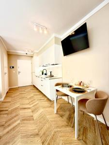 Una cocina blanca con una mesa y sillas blancas. en Garbary BLUE SOUL 40, en Poznan