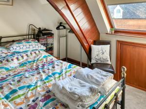a bedroom with a bed and a chair and a window at Chapel Court Loft Apartment in Beaumaris