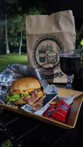 Una bandeja con un sándwich y una copa de vino. en Chalé Hospedagem Ecológica, en Ribeirão Pires 17 fotos más
