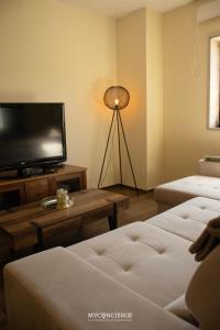 a living room with a flat screen tv and a table at Casa da Portelinha in Castelo de Paiva
