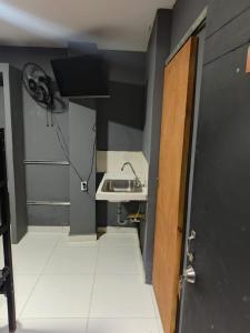 un bagno con un lavandino e una porta con un ventilatore di Dulce Hogar Aparta Hotel a Medellín