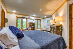 a bedroom with a blue bed and a living room at Hot Tub and Private Sauna Wausau Family Home in Wausau
