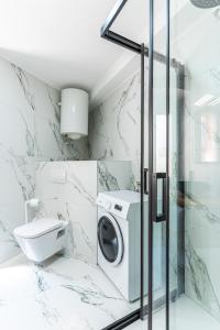 a bathroom with a washing machine and a toilet at Ilir Apartman in Cres +33 photos