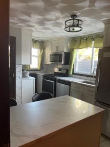 a kitchen with white cabinets and a large marble counter top at Peace get away in Saint Albans +12 photos