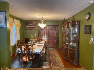 a dining room with a table and chairs and green walls at Peace get away in Saint Albans