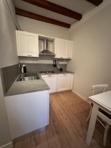 une cuisine avec des armoires blanches et un plancher en bois dans l'établissement Corso Como Suite, à Milan