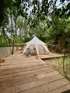 a white tent sitting on top of a wooden boardwalk at Gite tente LOTUS in Montesquieu