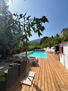 a swimming pool with a wooden deck and a swimming poolvisor at Gite tente LOTUS in Montesquieu